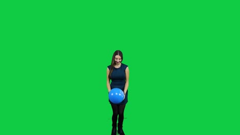 niña jugando con el globo frente a una pantalla verde