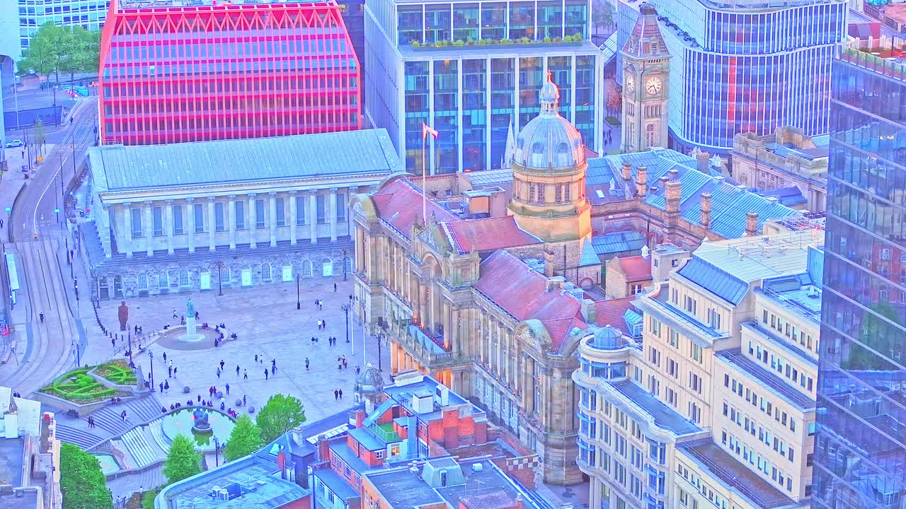 Drone footage captures Pigeon Park and Victoria Square in Birmingham, highlighting the Town Hall, Council House, and iconic city architecture as evening light bathes the urban landscape