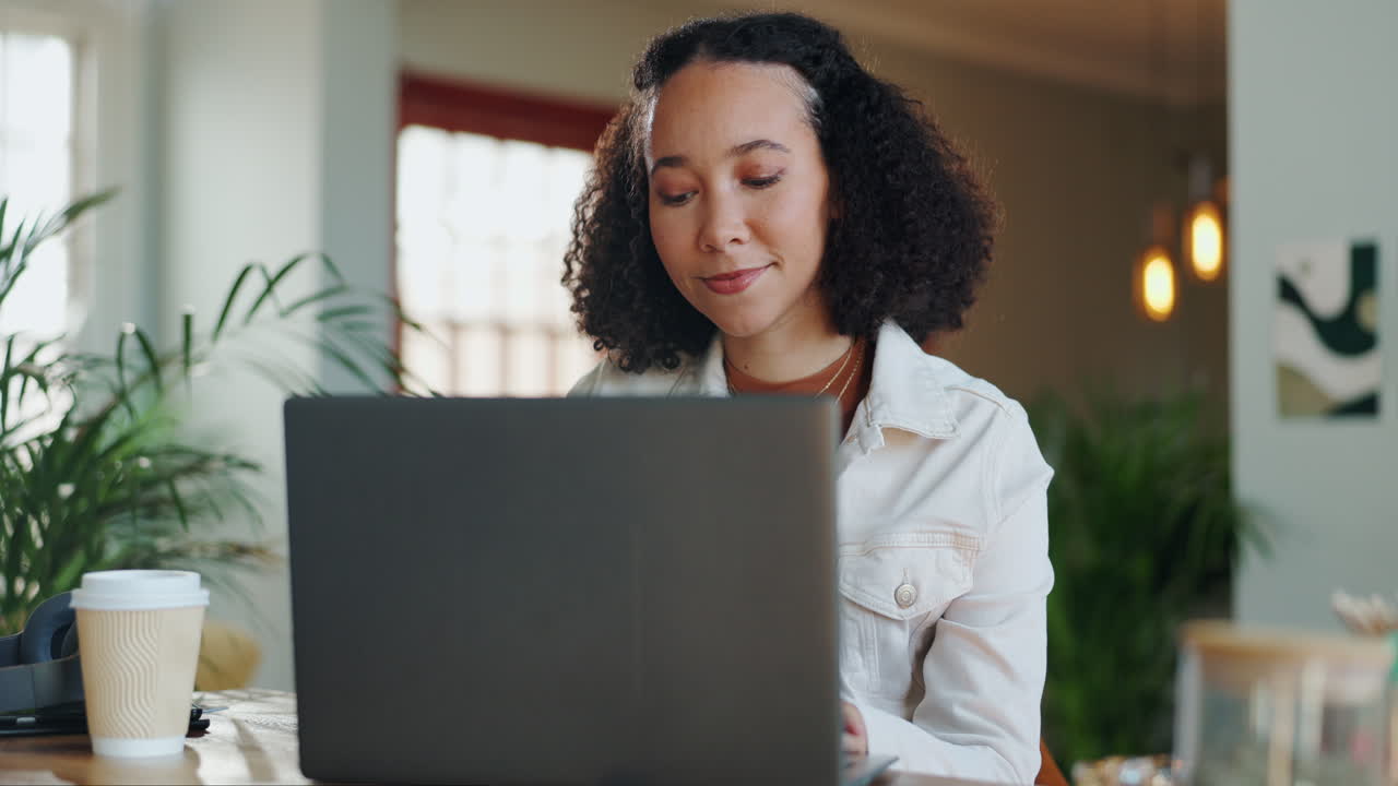 A woman working on her laptop at a desk