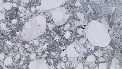 brash ice completely covering the surface in overcast lighting, top down drone zoom out shot