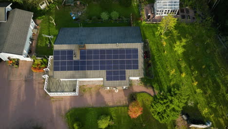 aerial view rising away from a solar powered house in middle of fall colored forest