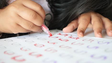 child practicing handwriting and coloring