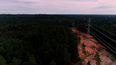 flying over coniferous forest with transmission towers and cable lines nearby