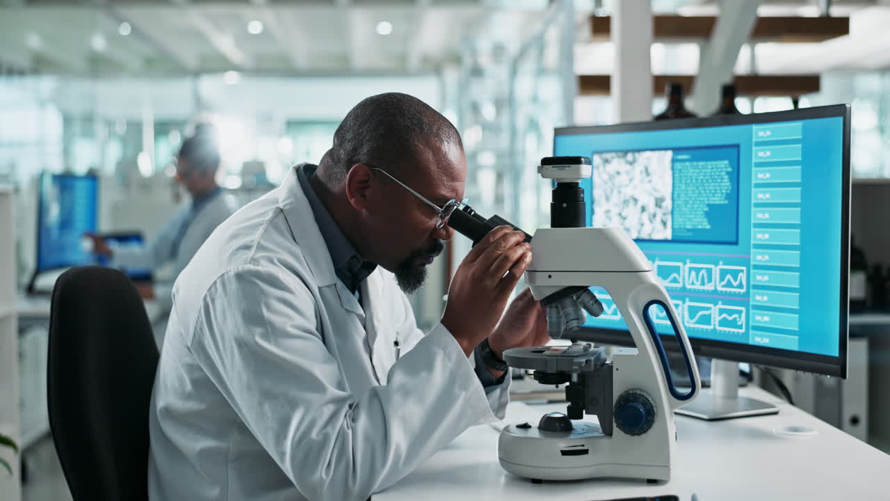 Scienziato al lavoro in un laboratorio con un microscopio
