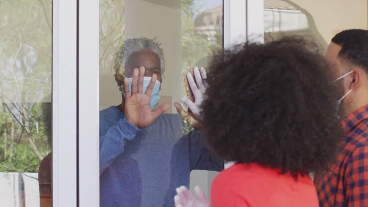 Senior man and couple touching each other through glass door
