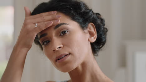 retrato de una hermosa mujer joven mirándose en el espejo con una piel perfecta y saludable tocando la cara con las manos disfrutando de una tez natural suave con cuidado de la piel antienvejecimiento preparándose en casa concepto de belleza