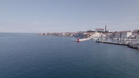 video with a drone of a rear aerial shot over the city of piran in slovenia, it begins advancing through the port and ends up ascending over the city in a aerial shot just above the central square