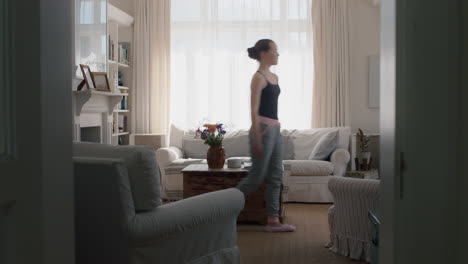 beautiful teenage girl dancing at home practicing ballet dance moves having fun rehearsing in living room