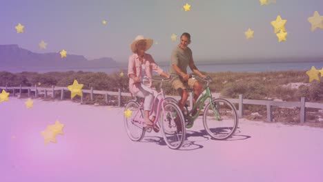 Múltiples-íconos-De-Estrellas-Doradas-Contra-Una-Pareja-De-Ancianos-Caucásicos-Andando-En-Bicicleta-Juntos-En-La-Playa