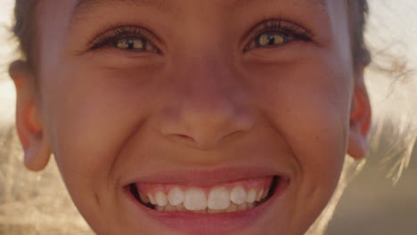 Portrait-of-mixed-race-girl-child-smiling-outdoors-at-sunset