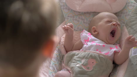 Elder-brother-lulling-baby-sister-to-sleep-in-rocking-chair