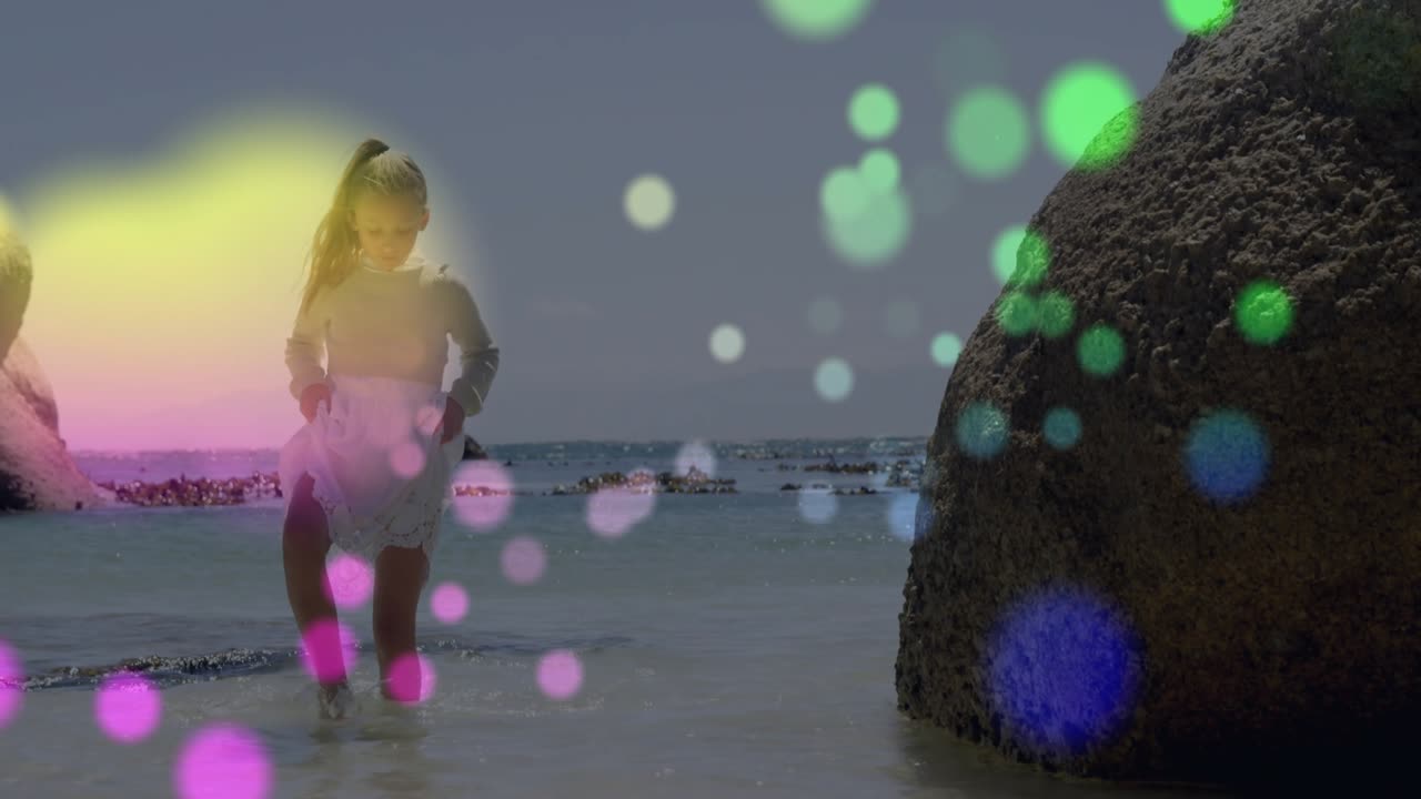 Child stepping into water triggers colorful dots drifting for tech demo, lifting skirt to keep dry