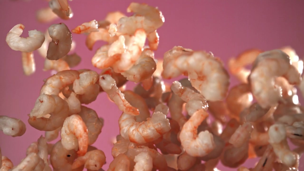 Gamberetti Cotti in Caduta al Rallentatore su Sfondo Rosa