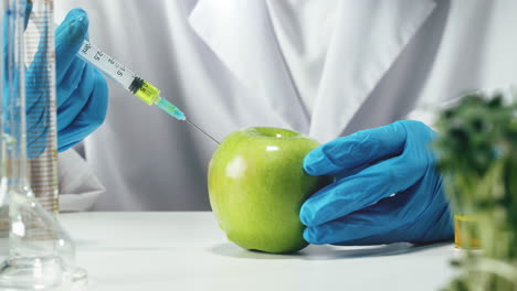 scientist injecting green apple in lab