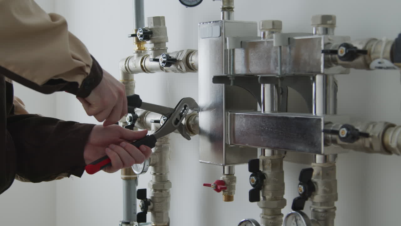 Unrecognizable Plumber Fixing Pipes