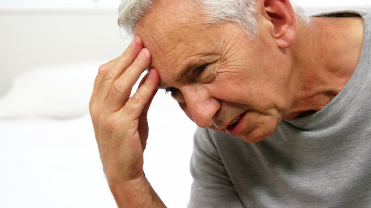 un anciano sufriendo en su cama.