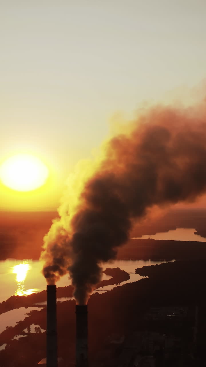 High voltage post. High-voltage tower sky background, factory pipe with smoke over it. Earth pollution and industrialization concept. Selective focus. Vertical video