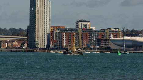 corto de un remolcador de trabajo en el solent en southampton con weston en el fondo