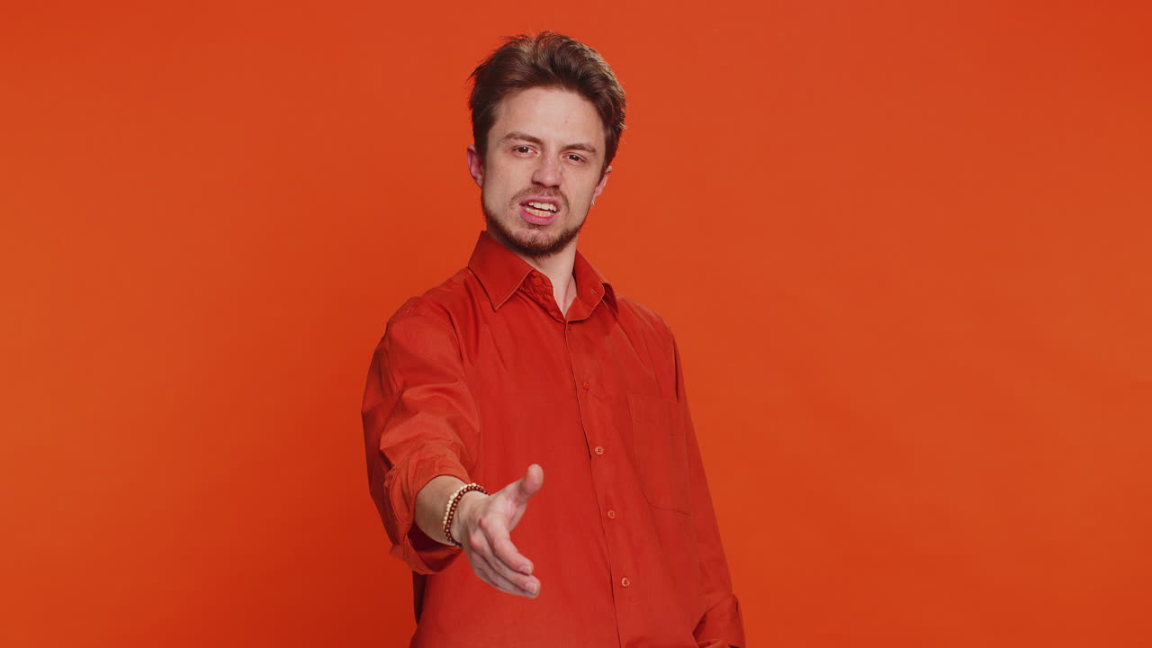 hombre caucásico extendiendo la mano a la cámara ofreciendo un apretón de manos saludando invitación de bienvenida