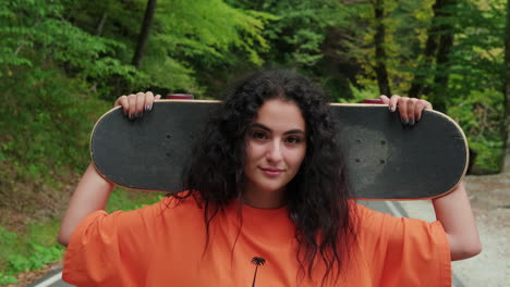 adolescente con una patineta en un bosque