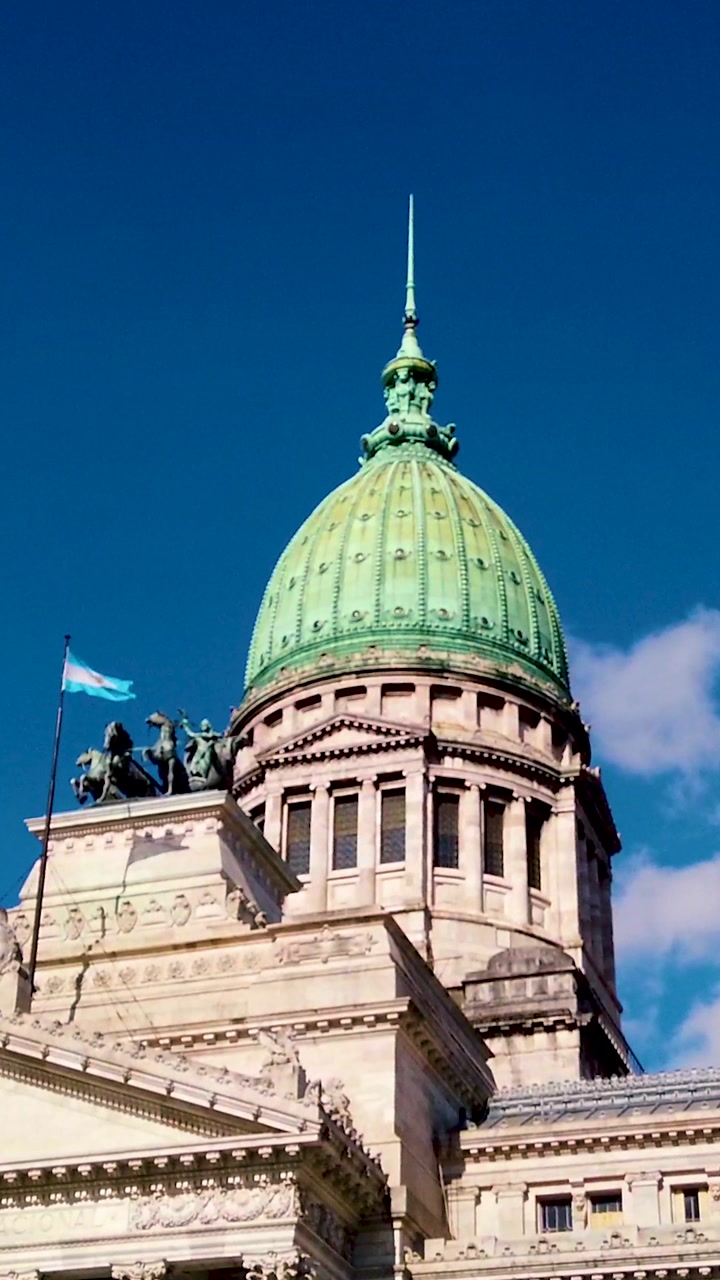 Vertical low angle view of Argentina National Congress dome with flag and statues in Buenos Aires neoclassical government landmark
