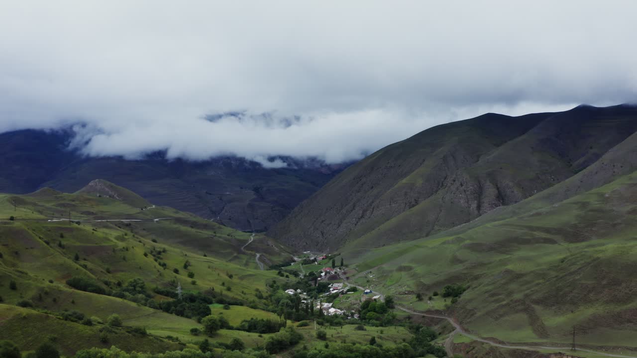 pueblo de valle de montaña con nubes