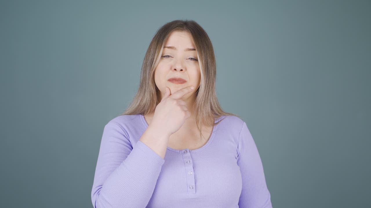 mujer joven mirando a la cámara con una expresión curiosa.