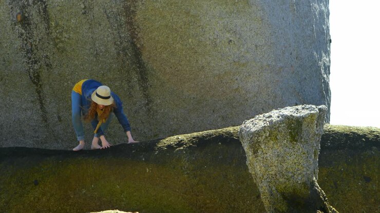 Woman standing on a rock at beach 4k