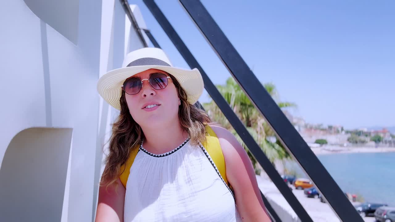 Young Woman Tourist Looking at the Sea on a Sunny Day