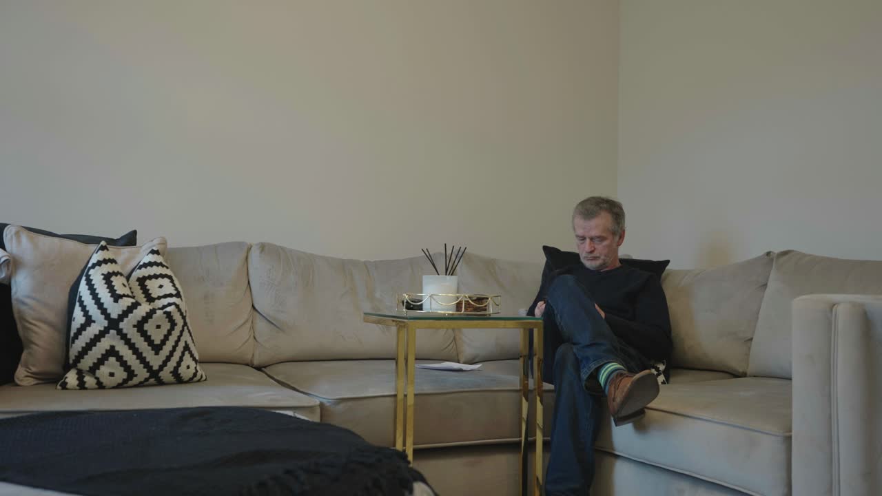 A man in his 50s makes a phone call at home