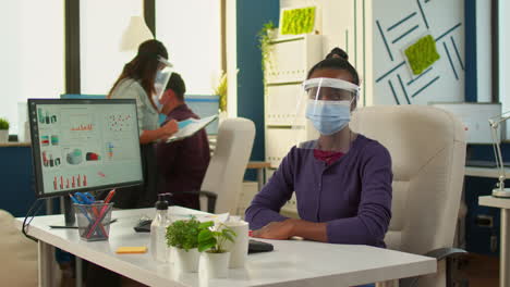 black employee with visor looking serious at camera