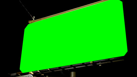 밤에 크로마 키 녹색 스크린으로 비어있는 광고판의 낮은 각도 뷰 4k