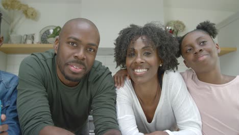 joyful family listening and laughing directly into webcam during video call