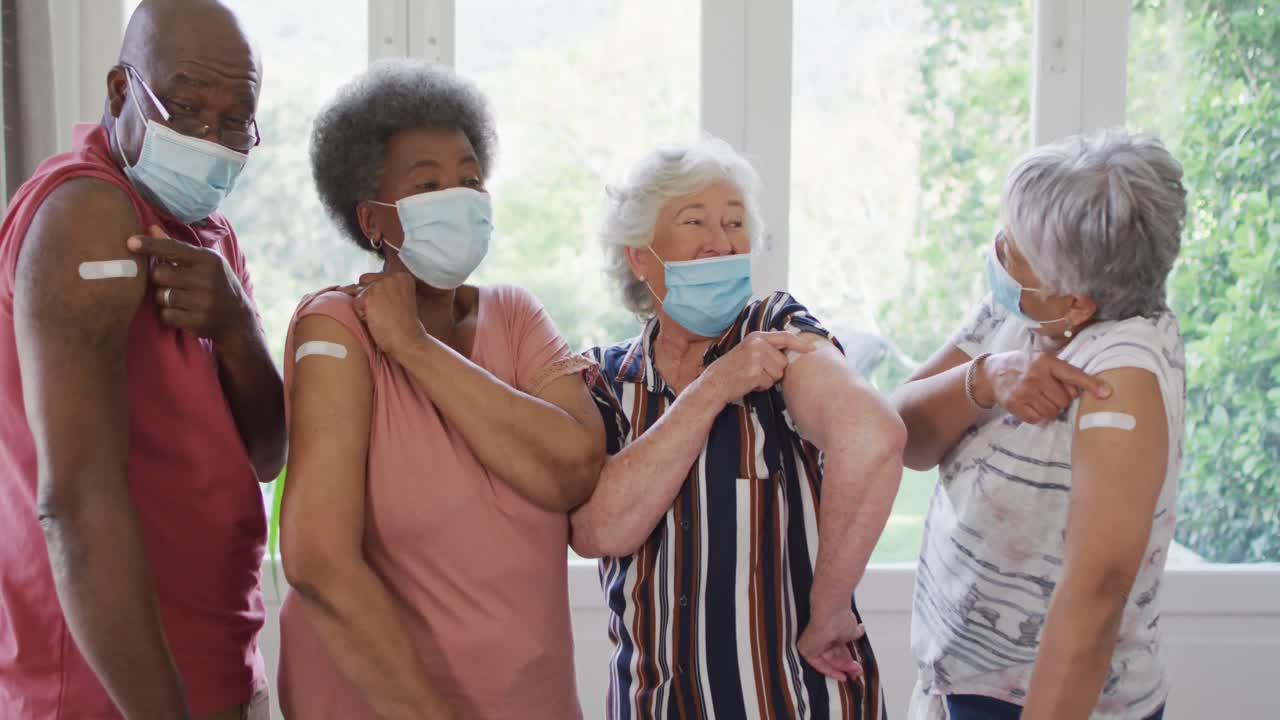 집에서 백신을 접종한 어깨를 보여주는 얼굴 마스크를 착용한 다양한 노인 그룹