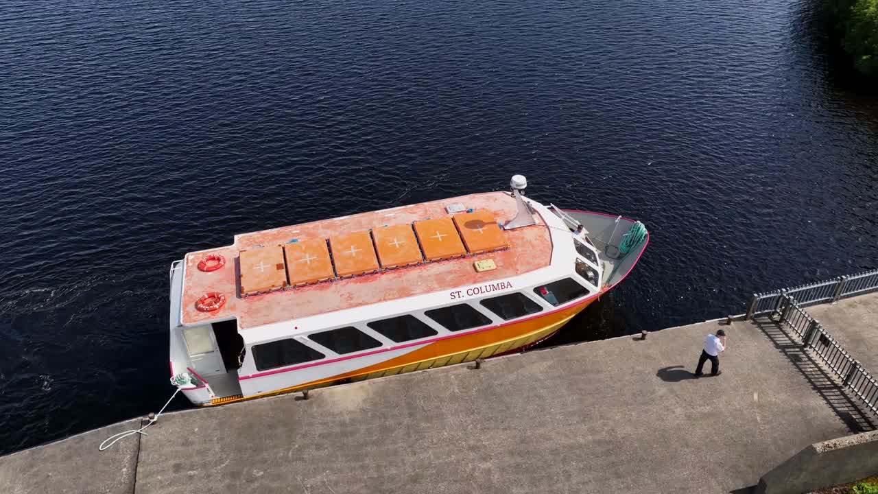 Lough Derg, County Donegal, Ireland, June 2023. Drone orbits clockwise around the St. Columba pilgrimage tour boat ferry at the dock taking passengers out to St. Patrick's Purgatory on Station Island.