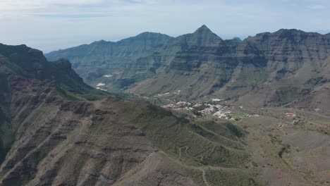 drone shot of mountains and canyons with a little village in gran canaria