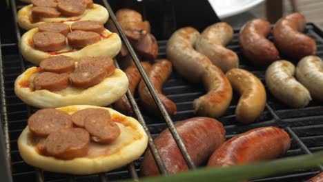 bbq sunny day sausages grilled food men laying out sausages on the bbq fire raw cooking mini pizza