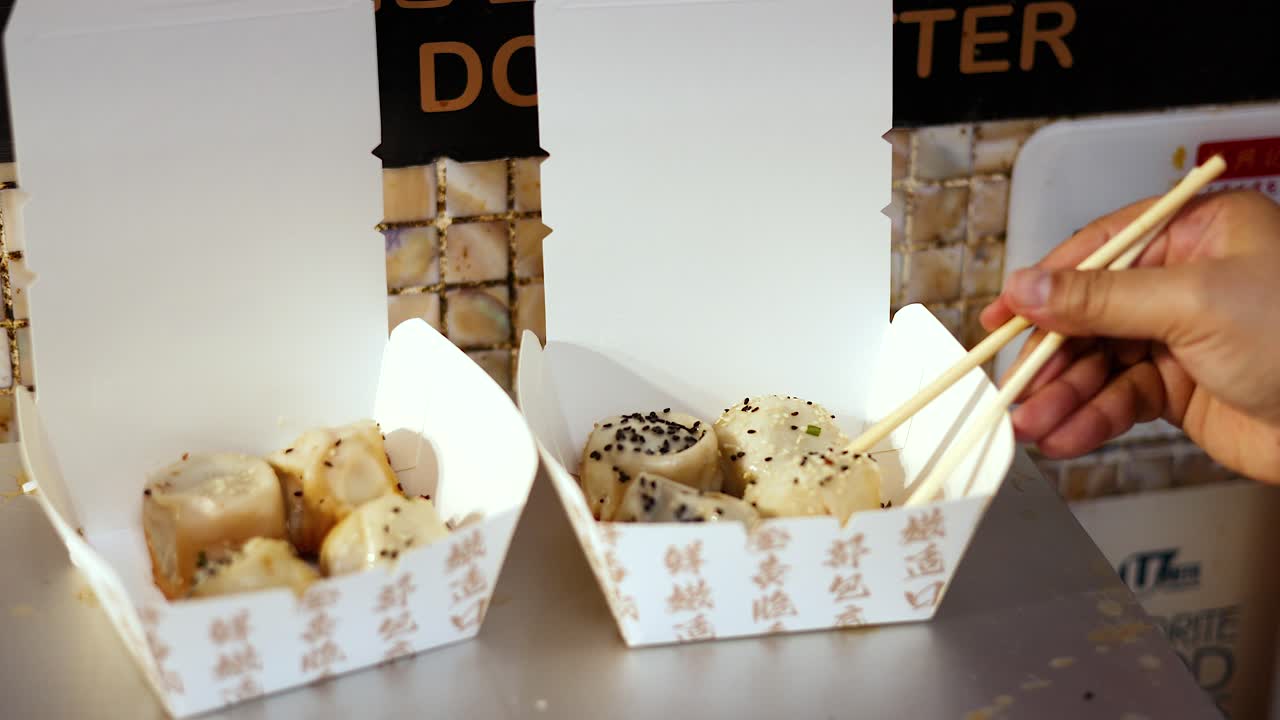 palillos para comer recogiendo panes de una caja de comida para llevar