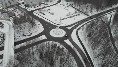 roundabout with traffic during winter covered with snow, aerial rising