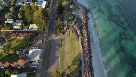 Vista-Aérea-Dividida-De-La-Playa-Y-La-Zona-Residencial-Durante-La-Puesta-De-Sol,-Disparo-Dinámico-De-Drones