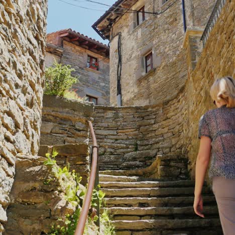 a tourist walks through the narrow streets of the village of rupit in catalonia