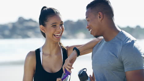 couple laughing and exercising on the beach