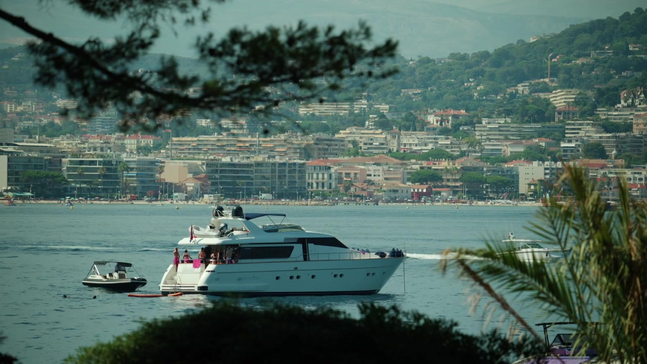 Yacht di lusso che arriva in un porto di una città costiera, invitando i viaggiatori a vivere vacanze estive e sport acquatici, Cannes, Francia