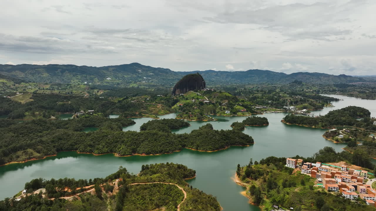 Panoramic drone shot circling the Piedra del Pe&ntilde;ol monolith, in cloudy Guatape, Colombia