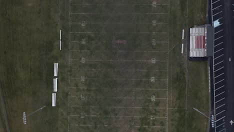 drone top shot of an empty american football field while snowing