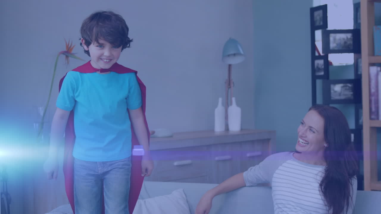 슈퍼히어로 케이프를 입은 아들과 함께 행복한 백인 어머니 위에 반 ⁇ 이는 반점의 애니메이션