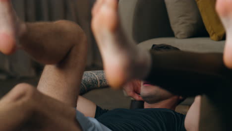 바닥에 누워있는 커플 훈련 다리. 건강한 몸을 위해 운동하는 가족