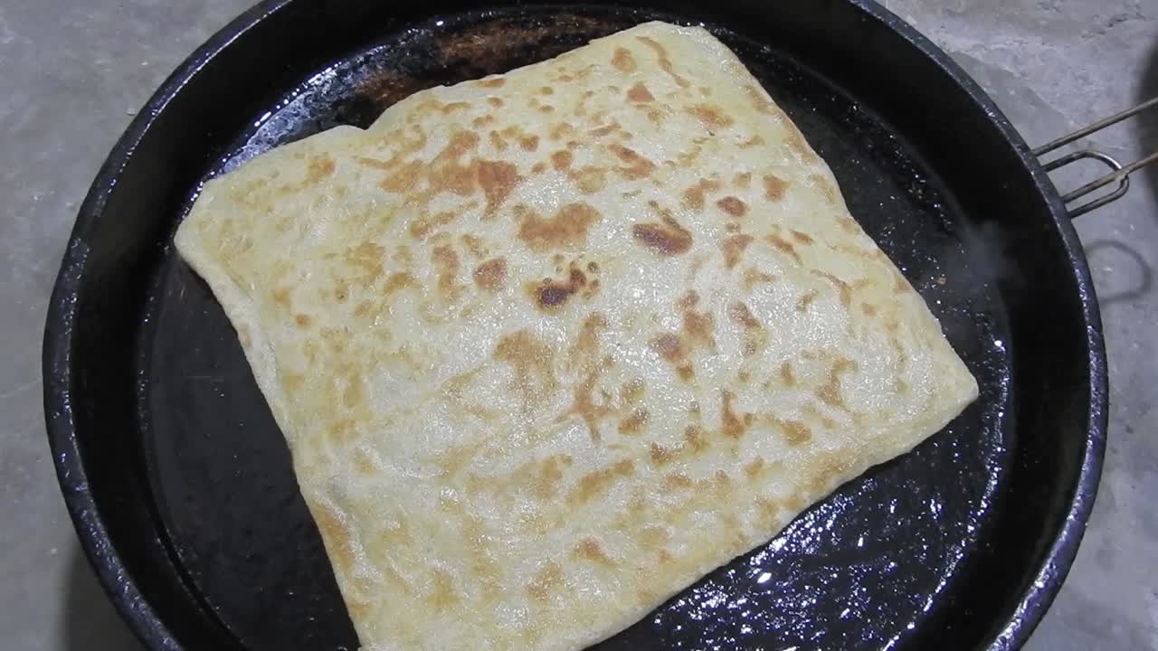 Special Moroccan pancakes called MSEMEN during the preparation in iron fryer
