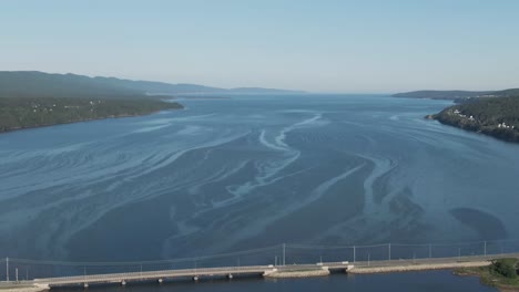 Cars-Travelling-On-The-Concrete-Bridge-Over-The-Saint-Lawrence-River-On-A-Bright-Day