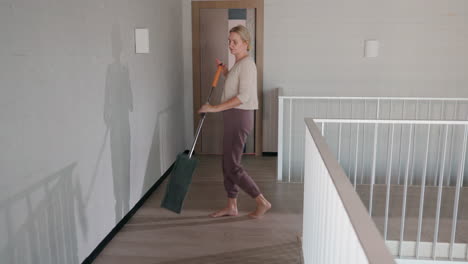 woman sweeping the floor in a modern home